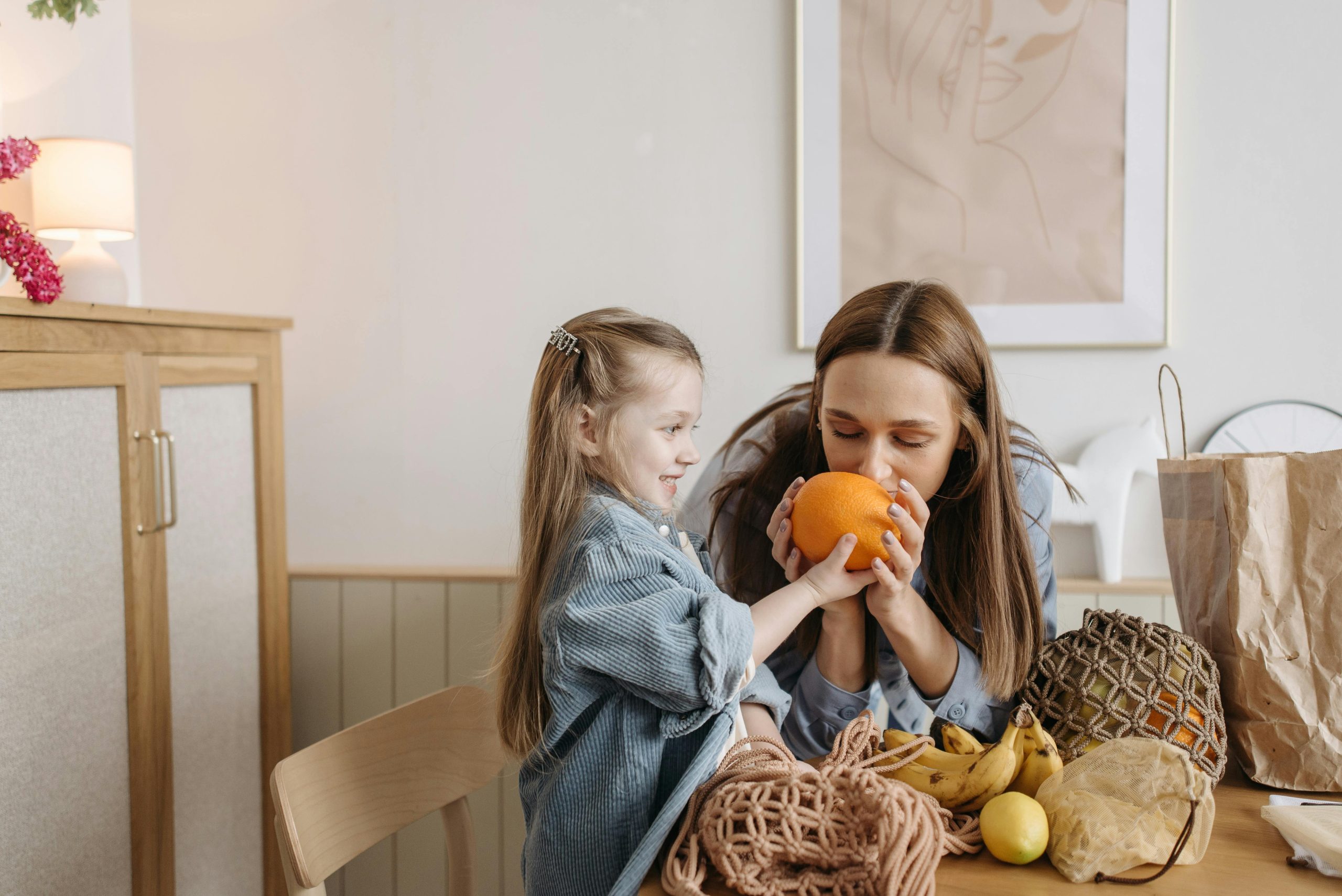 Child giving mum an orange to smell