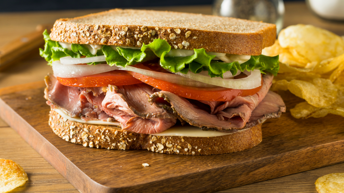 Sandwich on a board with salad and meat